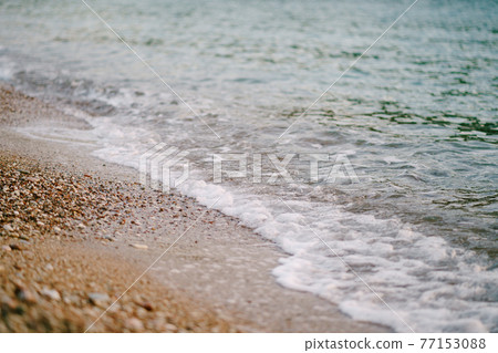Sea foam rolls on the sand on the beach Sea foam rolls on the sand on the beach 77153088