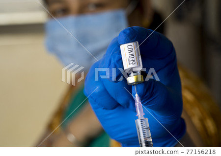 Doctor injecting vaccine into arm of patient Doctor injecting vaccine into arm of patient 77156218