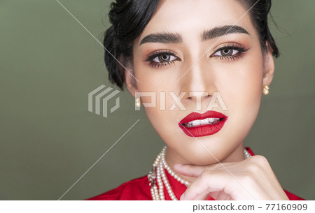 woman charming hairstyle wearing red traditional cheongsam while looking at camera 77160909