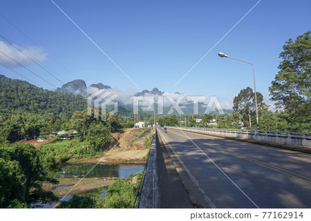 The destination of the road is a foggy mountain road to Pilok Village, Kanchanaburi Province, Thailand. The destination of the road is a foggy mountain road to Pilok Village, Kanchanaburi Province, Thailand. 77162914