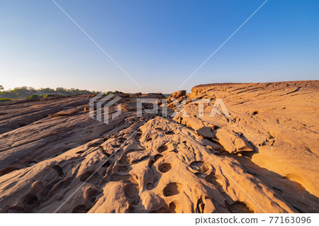 Sam Phan Bok, Ubon Ratchathani, Thailand. Dry rock reef in the Mekong River with mountain hills. Nature landscape background. Grand Canyon of Thailand. Sam Phan Bok, Ubon Ratchathani, Thailand. Dry rock reef in the Mekong River with mountain hills. Nature landscape background. Grand Canyon of Thailand. 77163096
