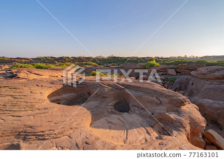 Sam Phan Bok, Ubon Ratchathani, Thailand. Dry rock reef in the Mekong River with mountain hills. Nature landscape background. Grand Canyon of Thailand. 77163101