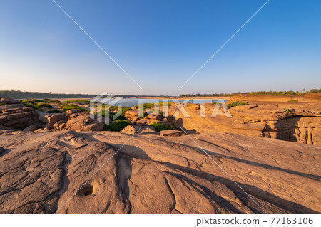 Sam Phan Bok, Ubon Ratchathani, Thailand. Dry rock reef in the Mekong River with mountain hills. Nature landscape background. Grand Canyon of Thailand. 77163106