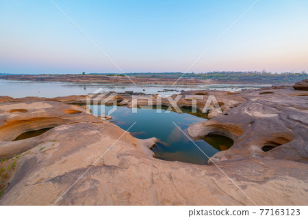 Sam Phan Bok, Ubon Ratchathani, Thailand. Dry rock reef in the Mekong River with mountain hills. Nature landscape background. Grand Canyon of Thailand. Sam Phan Bok, Ubon Ratchathani, Thailand. Dry rock reef in the Mekong River with mountain hills. Nature landscape background. Grand Canyon of Thailand. 77163123