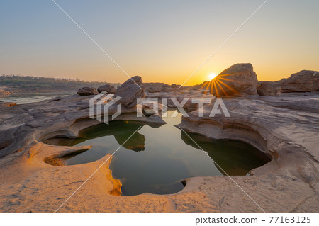 Sam Phan Bok, Ubon Ratchathani, Thailand. Dry rock reef in the Mekong River with mountain hills. Nature landscape background. Grand Canyon of Thailand. 77163125