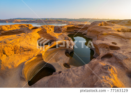 Sam Phan Bok, Ubon Ratchathani, Thailand. Dry rock reef in the Mekong River with mountain hills. Nature landscape background. Grand Canyon of Thailand. Sam Phan Bok, Ubon Ratchathani, Thailand. Dry rock reef in the Mekong River with mountain hills. Nature landscape background. Grand Canyon of Thailand. 77163129