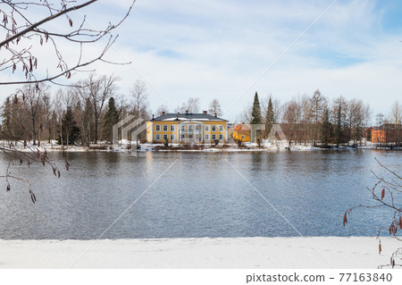 KOUVOLA, FINLAND - MARCH 21, 2019: Beautiful wooden Rabbelugn Manor - Takamaan Kartano. Wrede family house was built in 1820 on the river Kymijoki bank. KOUVOLA, FINLAND - MARCH 21, 2019: Beautiful wooden Rabbelugn Manor - Takamaan Kartano. Wrede family house was built in 1820 on the river Kymijoki bank. 77163840