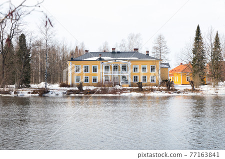 KOUVOLA, FINLAND - MARCH 21, 2019: Beautiful wooden Rabbelugn Manor - Takamaan Kartano. Wrede family house was built in 1820 on the river Kymijoki bank. KOUVOLA, FINLAND - MARCH 21, 2019: Beautiful wooden Rabbelugn Manor - Takamaan Kartano. Wrede family house was built in 1820 on the river Kymijoki bank. 77163841