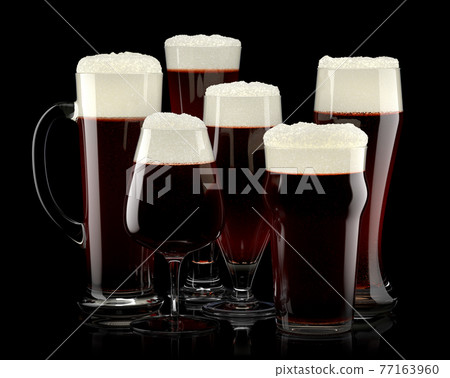 Set of fresh draft beer glasses with bubble froth isolated on black background. 77163960