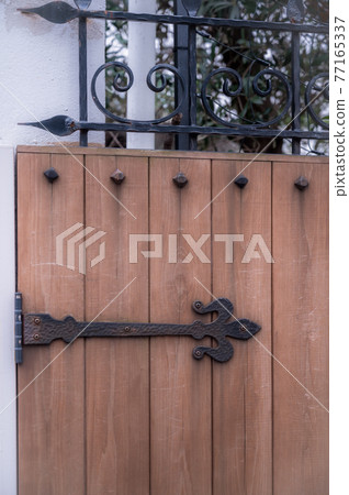 A cute wrought iron attached to the gate of the Western-style building 77165337