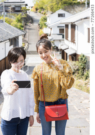A young woman and a friend taking a commemorative photo on Suya Slope on a girls' trip [April] 77166433