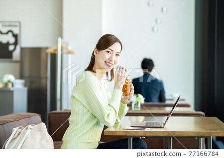 Young woman teleworking in a cafe Young woman teleworking in a cafe 77166784
