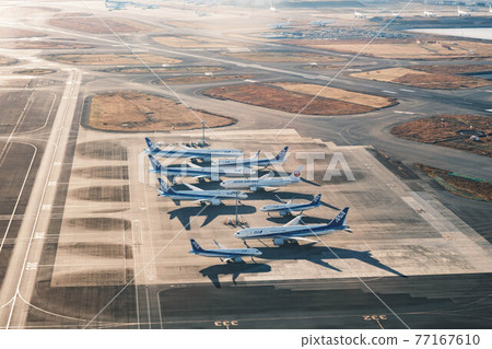 Numerous planes parked at the airport apron Numerous planes parked at the airport apron 77167610