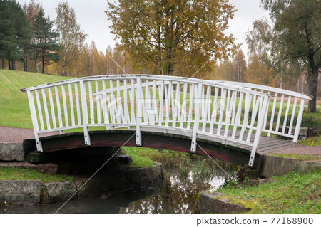 White bridge and pond in the city park Haanoja. Kouvola, Finland White bridge and pond in the city park Haanoja. Kouvola, Finland 77168900
