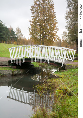 White bridge and pond in the city park Haanoja. Kouvola, Finland White bridge and pond in the city park Haanoja. Kouvola, Finland 77168902