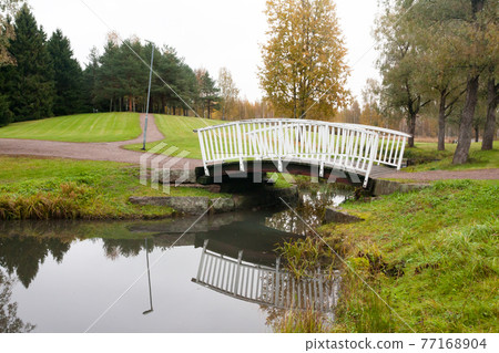 White bridge and pond in the city park Haanoja. Kouvola, Finland 77168904