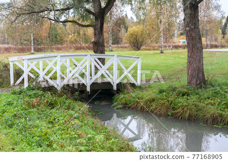 White bridge and pond in the city park Haanoja. Kouvola, Finland White bridge and pond in the city park Haanoja. Kouvola, Finland 77168905