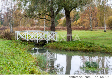 White bridge and pond in the city park Haanoja. Kouvola, Finland White bridge and pond in the city park Haanoja. Kouvola, Finland 77168906