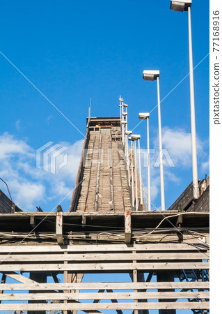 Abandoned wooden ski jumping hill on blue sky background in Kouvola, Finland 77168916