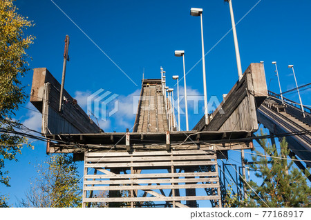 Abandoned wooden ski jumping hill on blue sky background in Kouvola, Finland 77168917