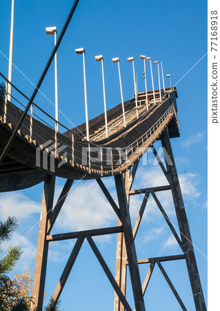 Abandoned wooden ski jumping hill on blue sky background in Kouvola, Finland 77168918