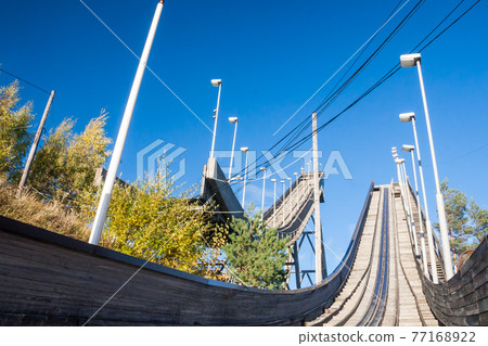 Abandoned wooden ski jumping hill on blue sky background in Kouvola, Finland Abandoned wooden ski jumping hill on blue sky background in Kouvola, Finland 77168922
