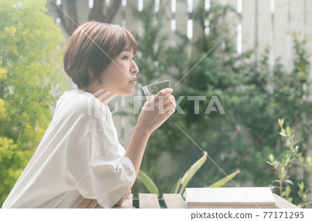 Young woman reading on the terrace 77171295