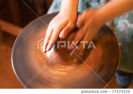 Potter's hands. Making clay products on a potter's wheel. Pottery master class. 77173529