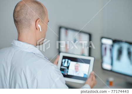 Doctor calling coworker Doctor calling coworker 77174443