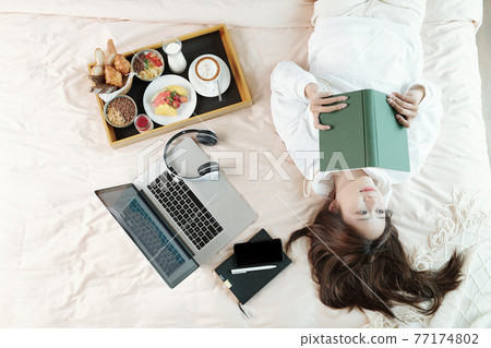 Woman reading thought provoking book Woman reading thought provoking book 77174802