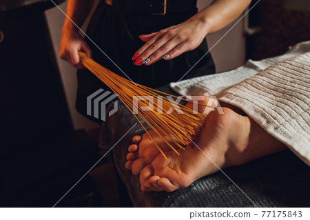 massage of female feet with bamboo sticks. massage of female feet with bamboo sticks. 77175843