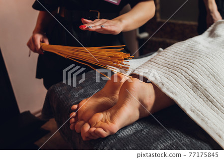 massage of female feet with bamboo sticks. massage of female feet with bamboo sticks. 77175845