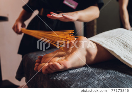 massage of female feet with bamboo sticks. massage of female feet with bamboo sticks. 77175846