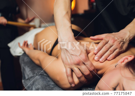 An attractive caucasian woman lying down on a massage bed at a spa. An attractive caucasian woman lying down on a massage bed at a spa. 77175847