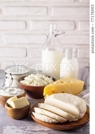 Set of different dairy products (milk, sour cream, cottage cheese, yogurt and butter) on a light stone countertop. Copy space. 77176003