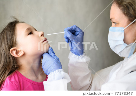 COVID-19 PCR test and kid, nurse holds swab for nasal sample from adorable child 77178347