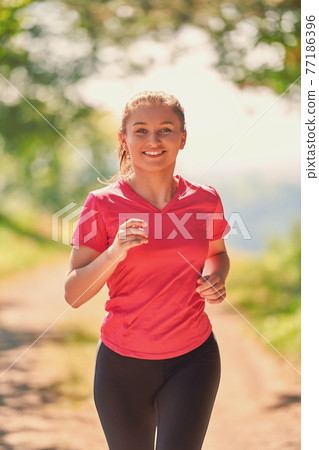 woman enjoying in a healthy lifestyle while jogging woman enjoying in a healthy lifestyle while jogging 77186396
