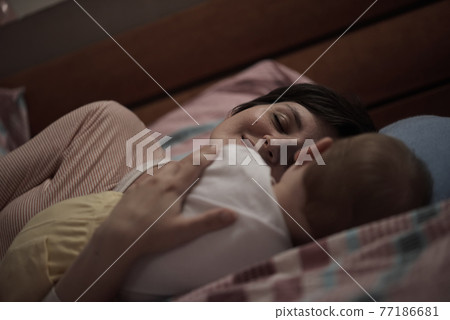 mother is playing with baby at home 77186681