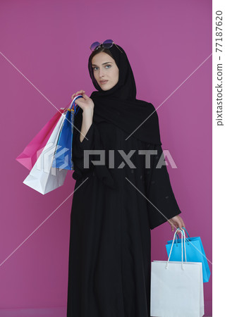 Happy muslim girl posing with shopping bags Happy muslim girl posing with shopping bags 77187620
