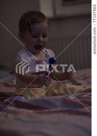 cute little one year old baby and making first steps in bed 77187868