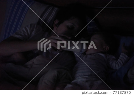 baby eating milk from bottle 77187870