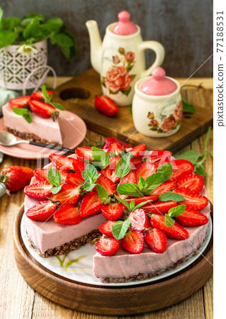 Summer diet dessert without baking Gluten-free, birthday menus. Strawberry cheesecake on a granola with fresh strawberries on a on rustic wooden table. 77188531