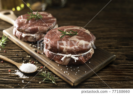 Fresh raw pieces of beef meat on a cutting board 77188660