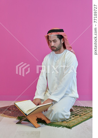 Young muslim man reading Quran during Ramadan 77189727