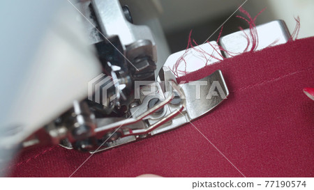 Shooting of tailor woman sewing order on electric overlock 77190574