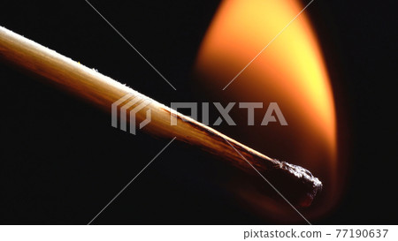Photo of burning wooden matchstick on black 77190637