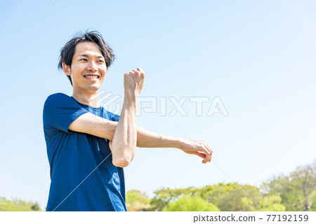 年輕人在公園跑步前伸展 77192159