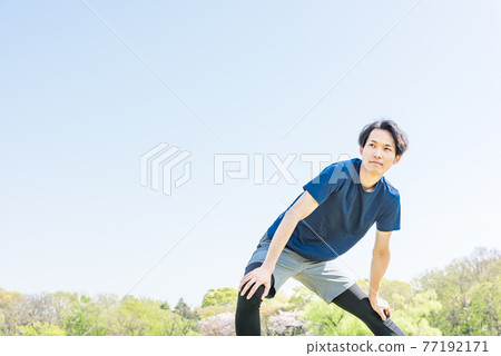 Young man stretching before running in the park Young man stretching before running in the park 77192171