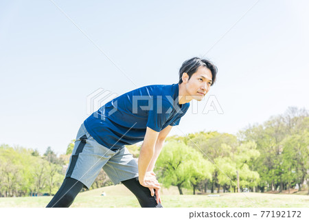 年輕人在公園跑步前伸展 77192172