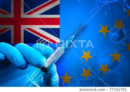 Tuvalu Covid-19 Vaccination Campaign. Hand in a blue rubber glove holds a syringe with covid-19 virus vaccine in front of Tuvalu flag 77192761